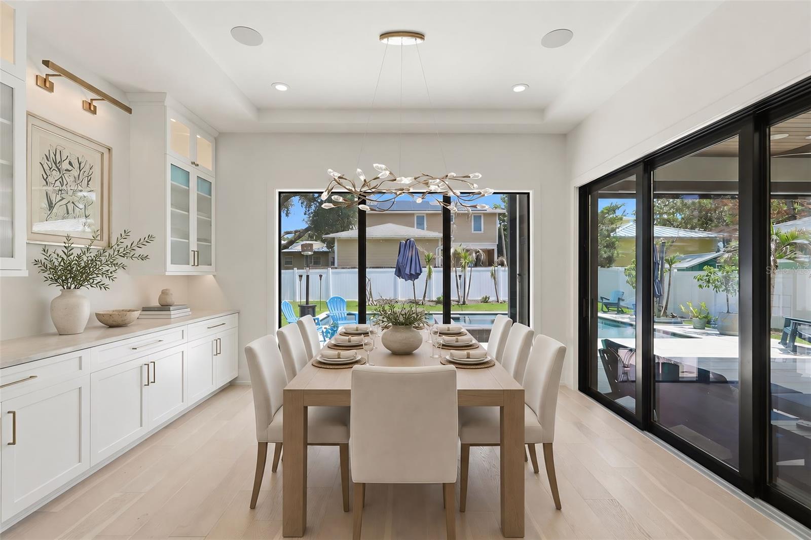 Dining area with custom cabinetry and designer lighting