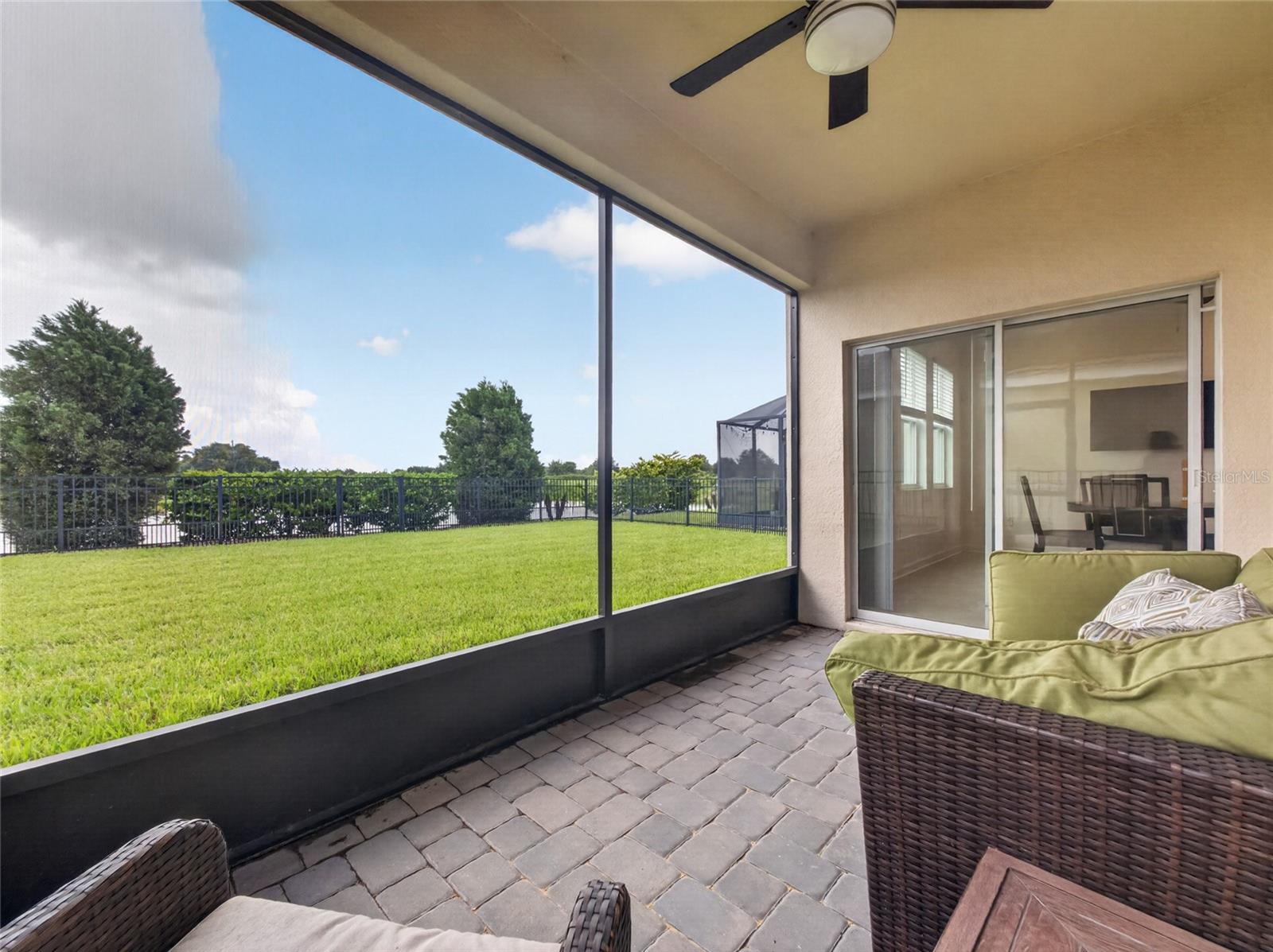 Screened-in pavered lanai overlooking a fully fenced backyard with beautiful golf course viewsthe perfect spot to relax and enjoy Florida living.