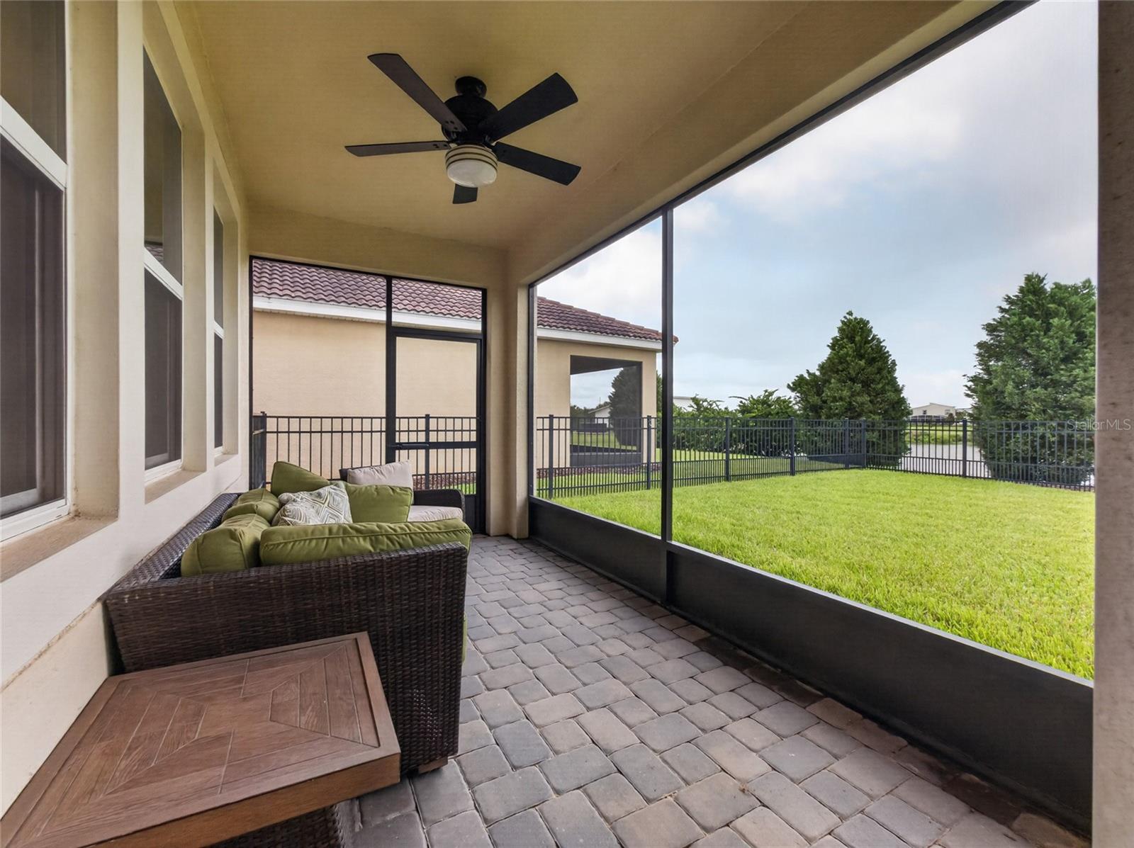 Screened-in pavered lanai overlooking a fully fenced backyard with beautiful golf course viewsthe perfect spot to relax and enjoy Florida living.