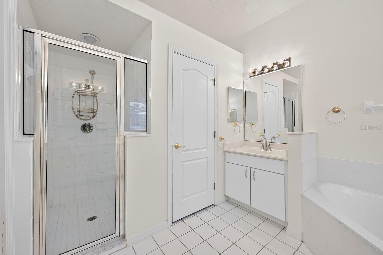 The PRIVATE EN SUITE BATH features dual vanities, a relaxing garden tub, a separate step-in shower with a NEWER LIGHT (2023), and a private water closet.
