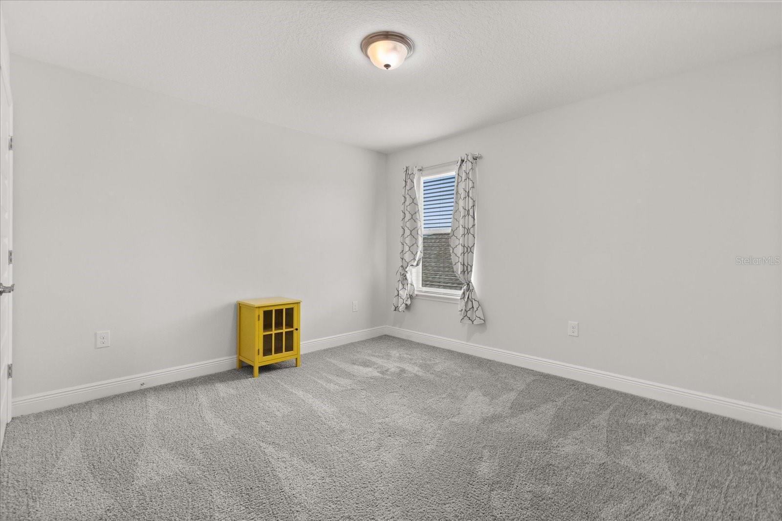 Large upstairs bedroom/office with spacious closet next to bathroom with dual sinks.