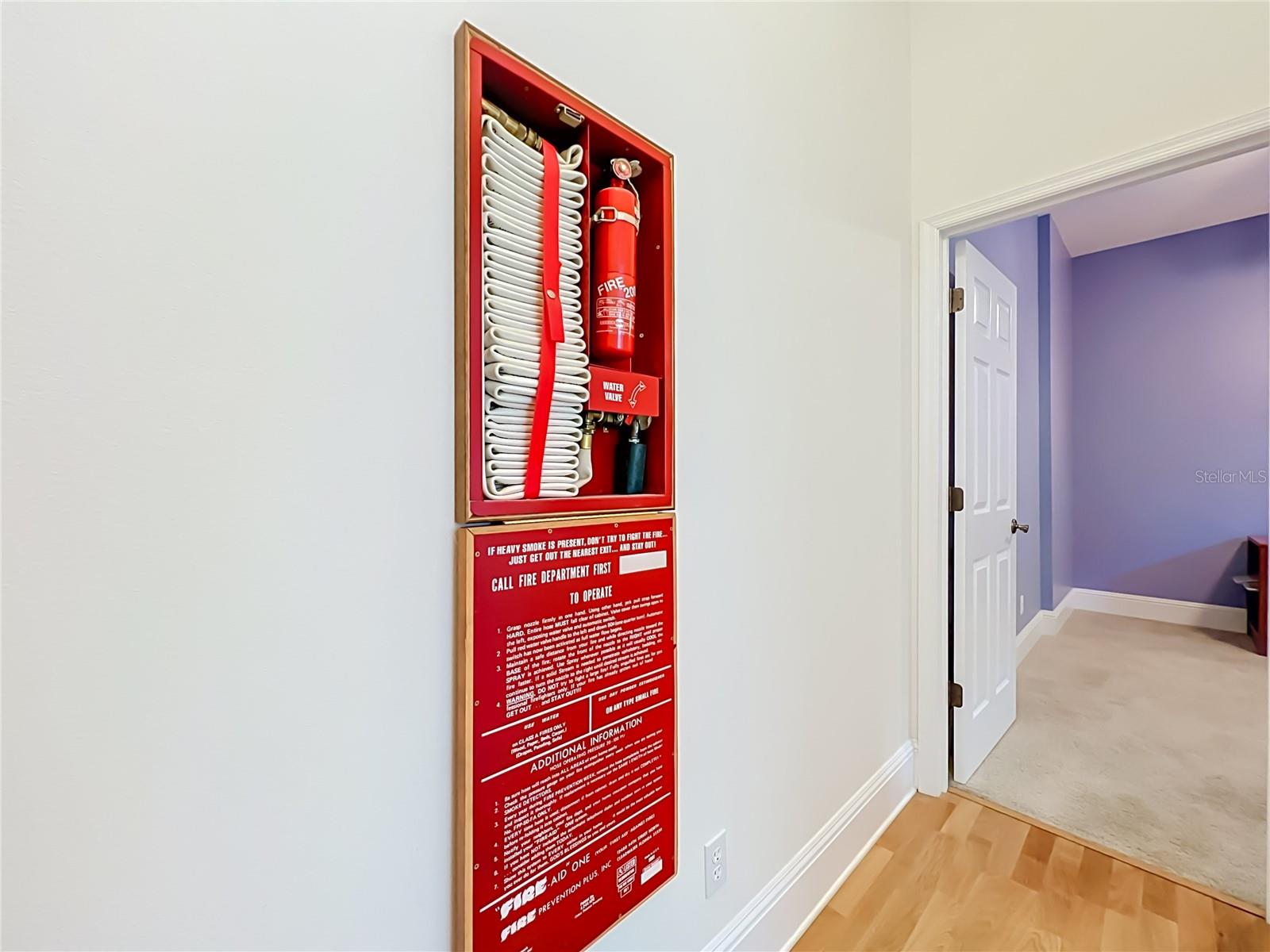 BUILDER INSTALLED THIS FIRE EXTENGUISHER WITH HOSE CONNECTED TO HOME WATER SUPPLY