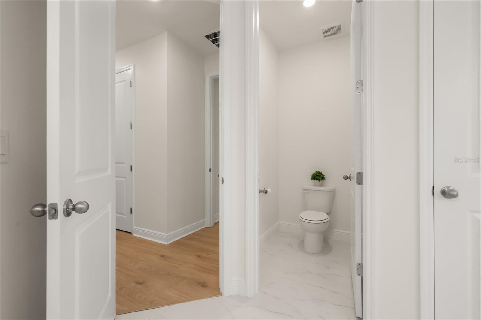 Luxurious primary bathroom with shower, dual vanity, soaker tub, and water closet