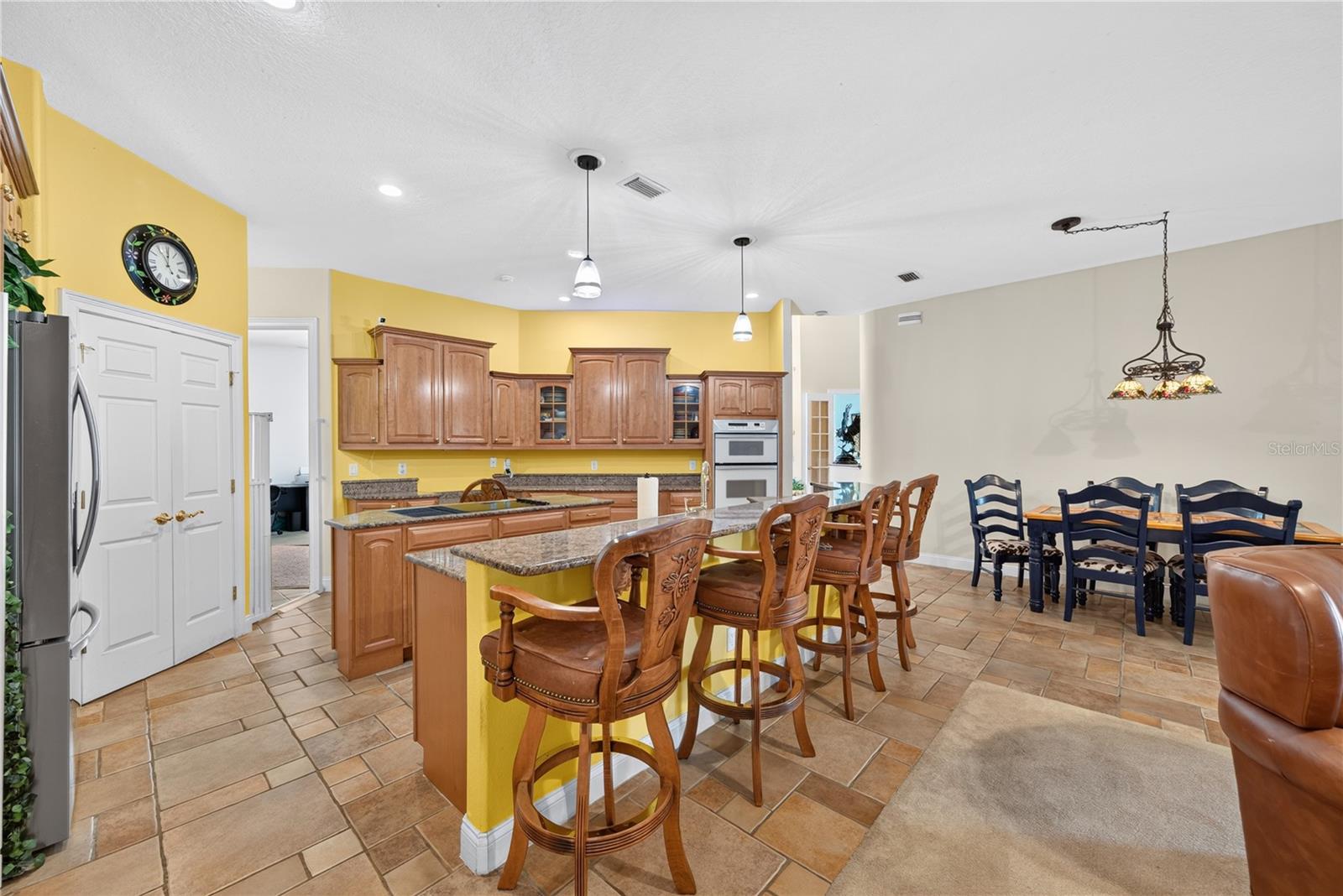 Kitchen with walk-in pantry, cooking island, bar seating and an abundance of cabinetry.