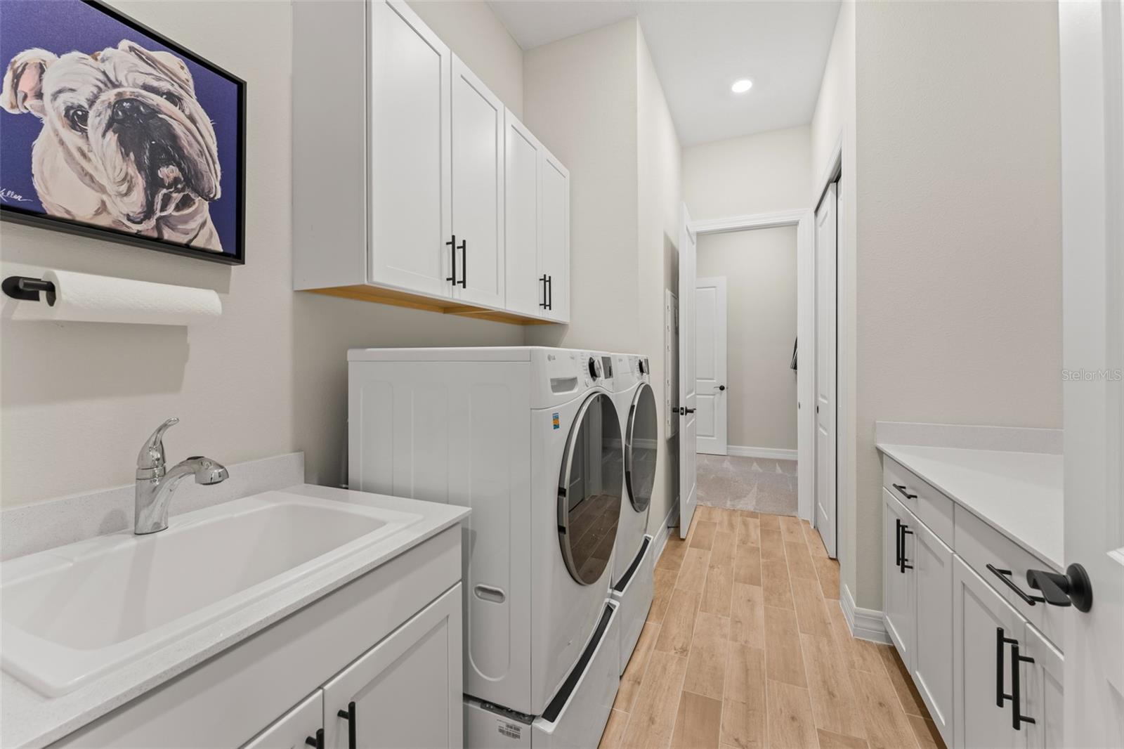 Upgraded laundry with cabinets, countertops and sink.