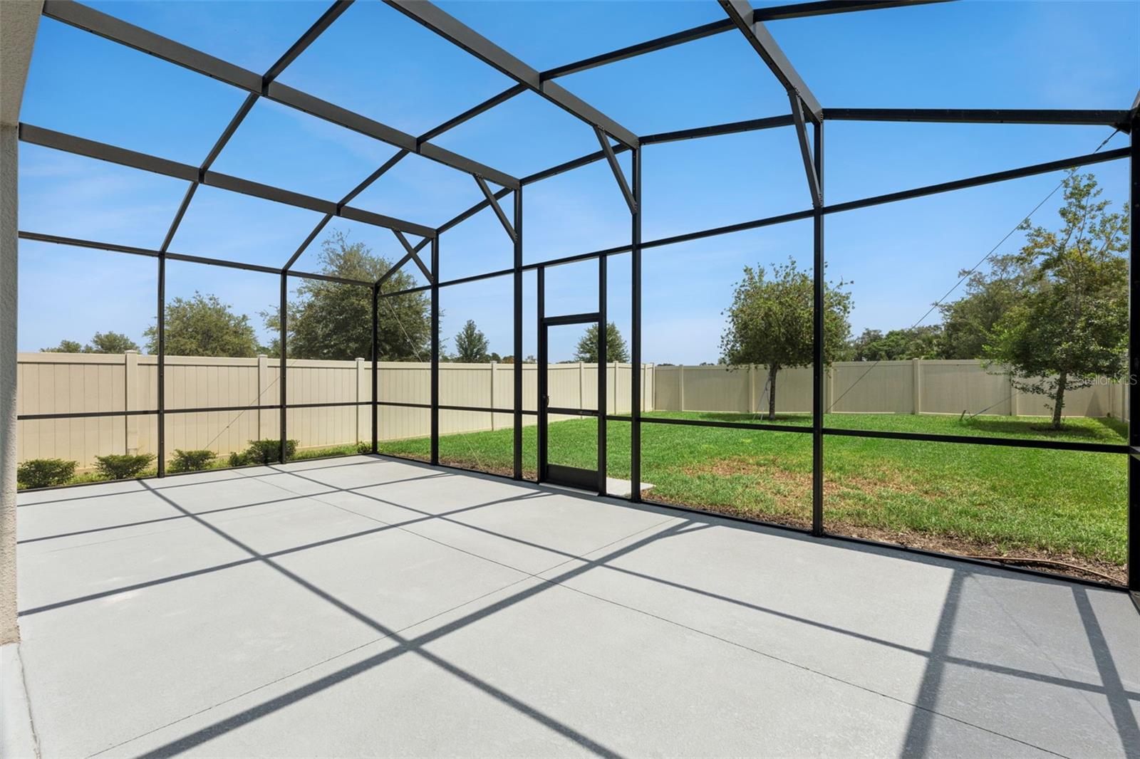 Screened Patio  Another view of the screened patio showcases its open layout and convenient access to the grassy backyard.