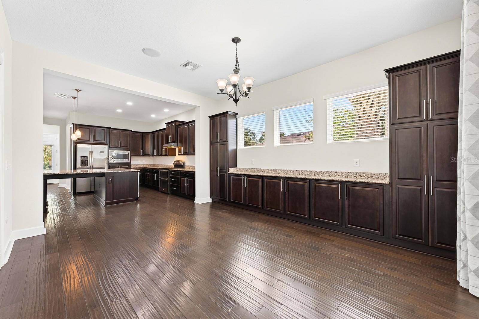 The rich cabinetry extends from the kitchen into the dining room for endless storage.