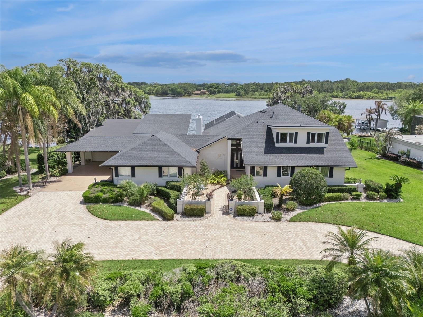 Garage space accommodates up to 6 cars, plus a 2-car carport and a large circular driveway.