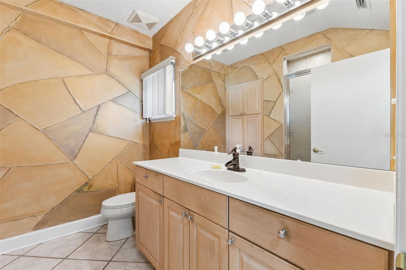 Full-size bathroom located near the laundry room and garage entry.