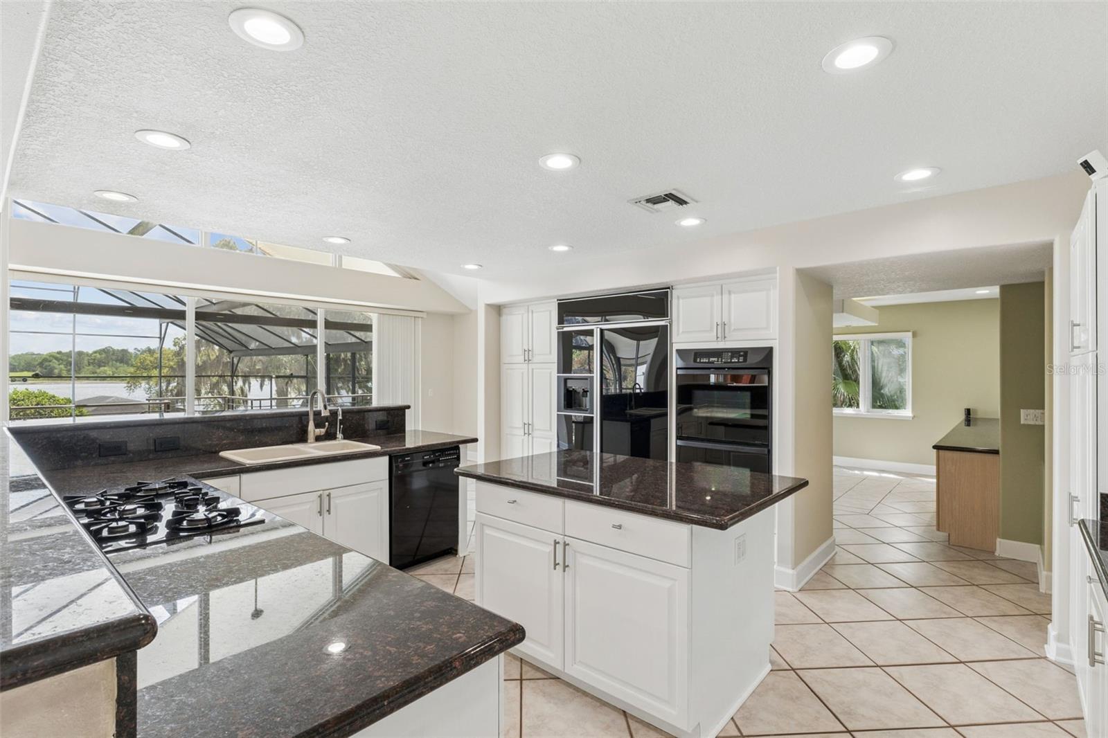 Spacious kitchen with lake views, center island, and seamless flow into the dining room.