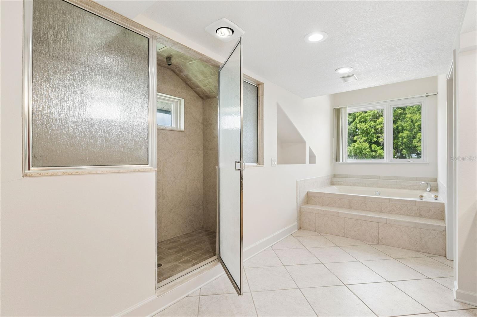 Primary bathroom with separate tub and walk-in shower.