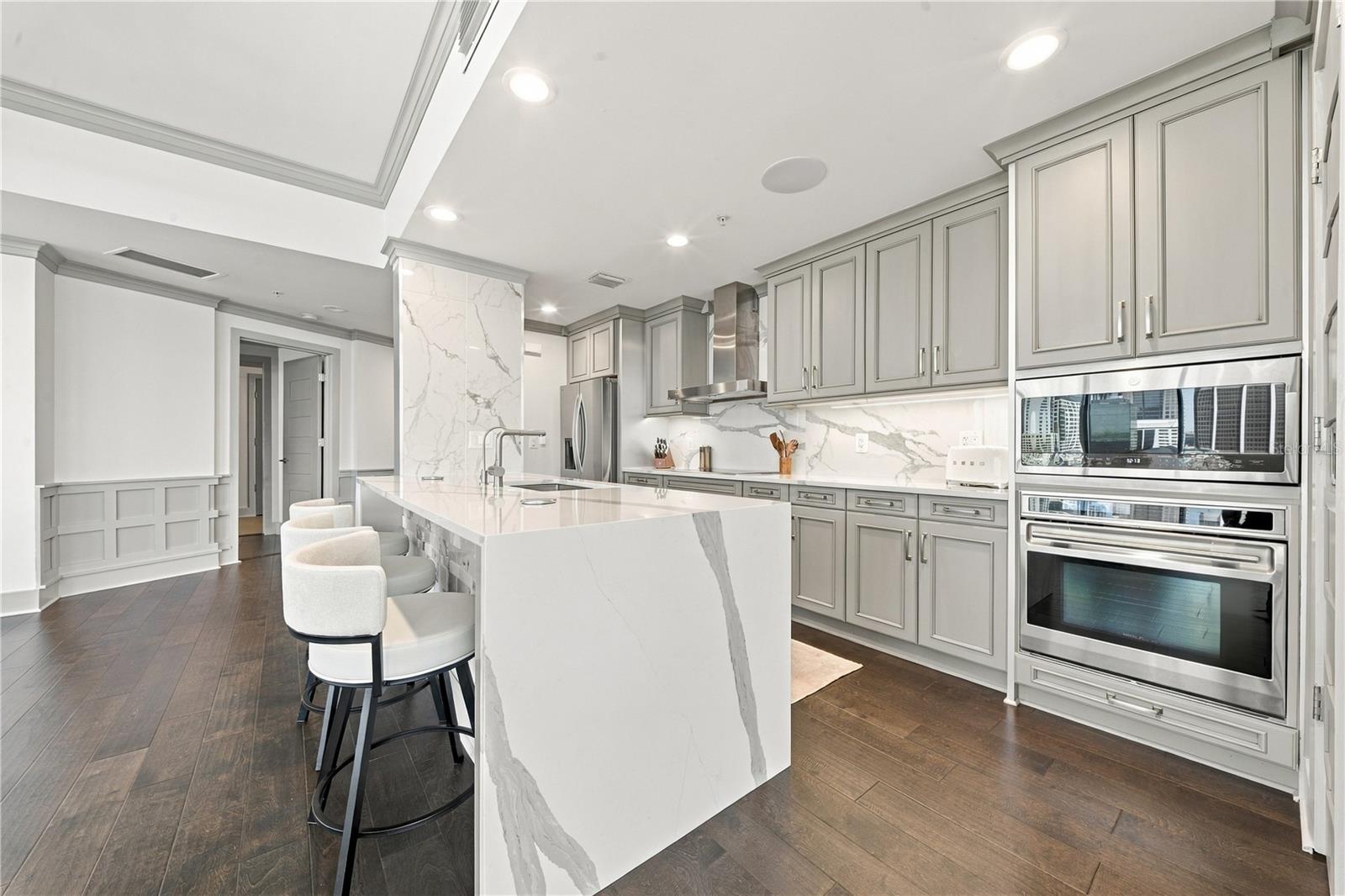 Kitchen | Quartzite countertops and full-height slab backsplash pair with streamlined cabinetry