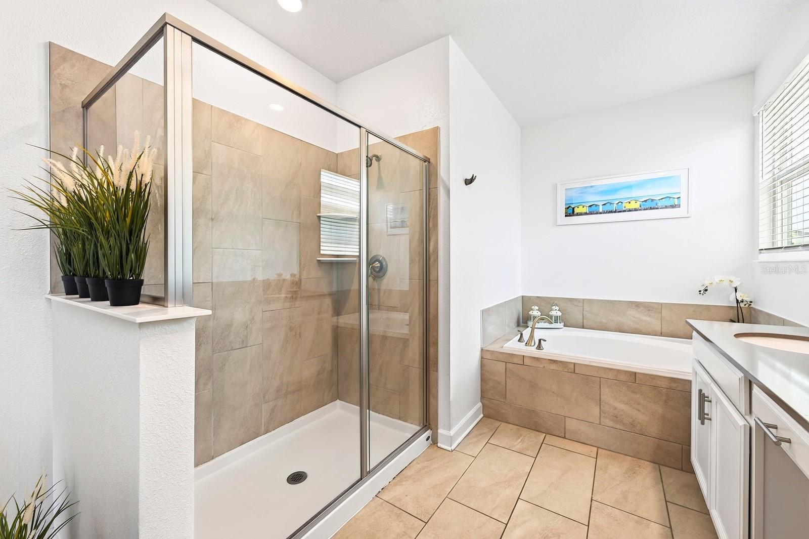 The Primary private en-suite bath boasts dual sinks, a GARDEN TUB, step-in shower, and private water closet.