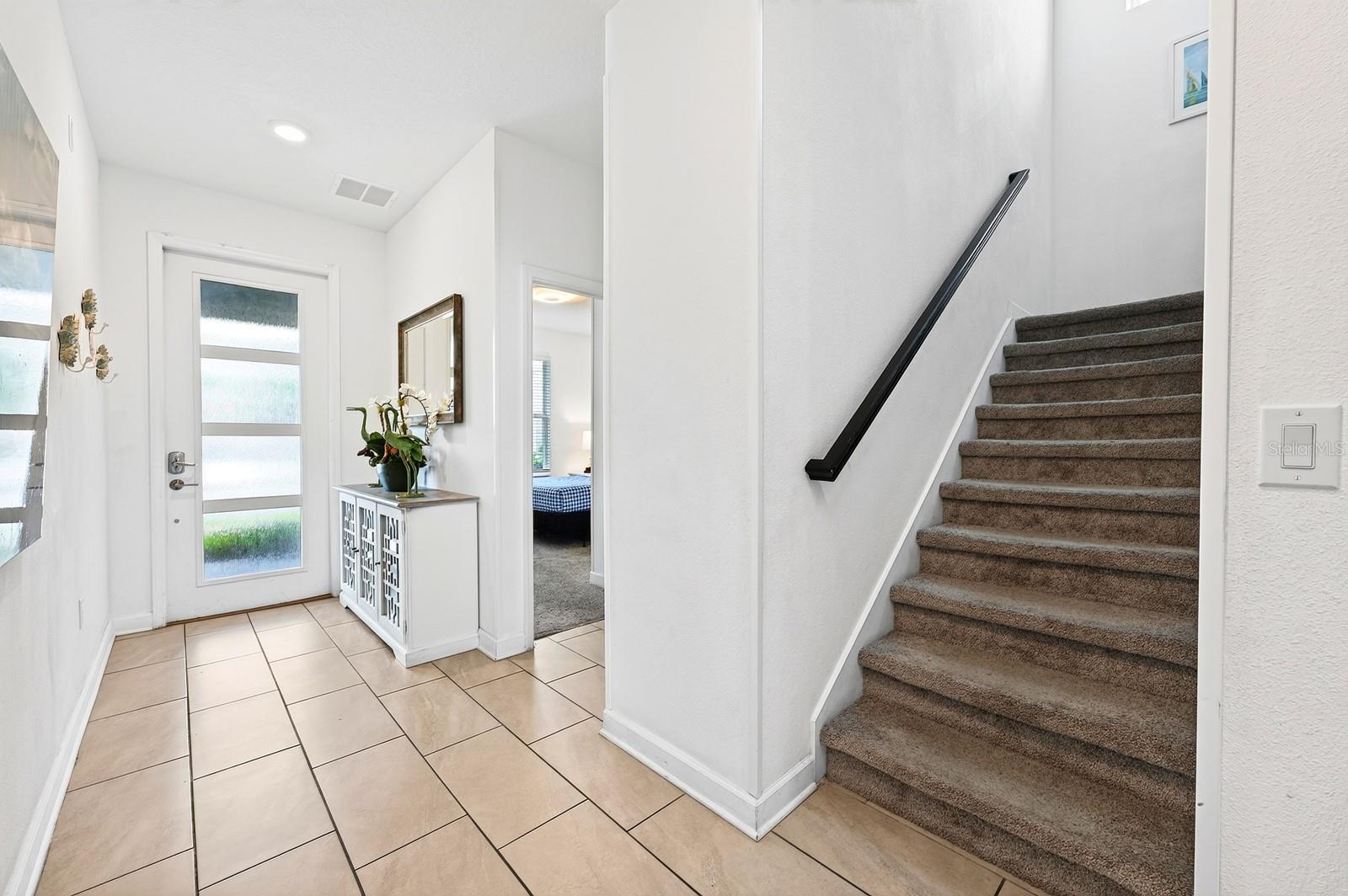 A brick paver driveway leads to the attached 1-car garage, beautifully accented with STONE FACING, while a stylish 4-LITE GLASS-PANELED FRONT DOOR welcomes you inside.