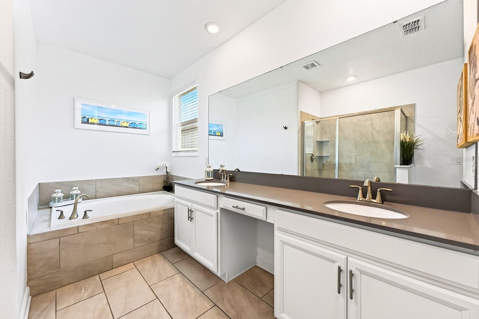 The Primary private en-suite bath boasts dual sinks, a GARDEN TUB, step-in shower, and private water closet.