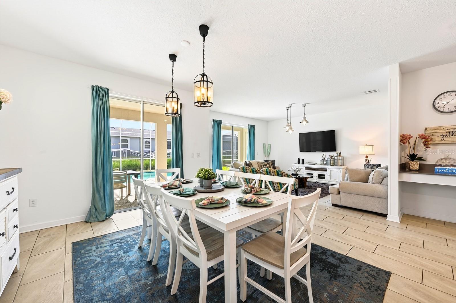 TWO SETS OF SLIDING GLASS DOORS bring in abundant natural light and create a seamless connection to the pool area, while CONTEMPORARY LIGHTING throughout adds a polished finishing touch.
