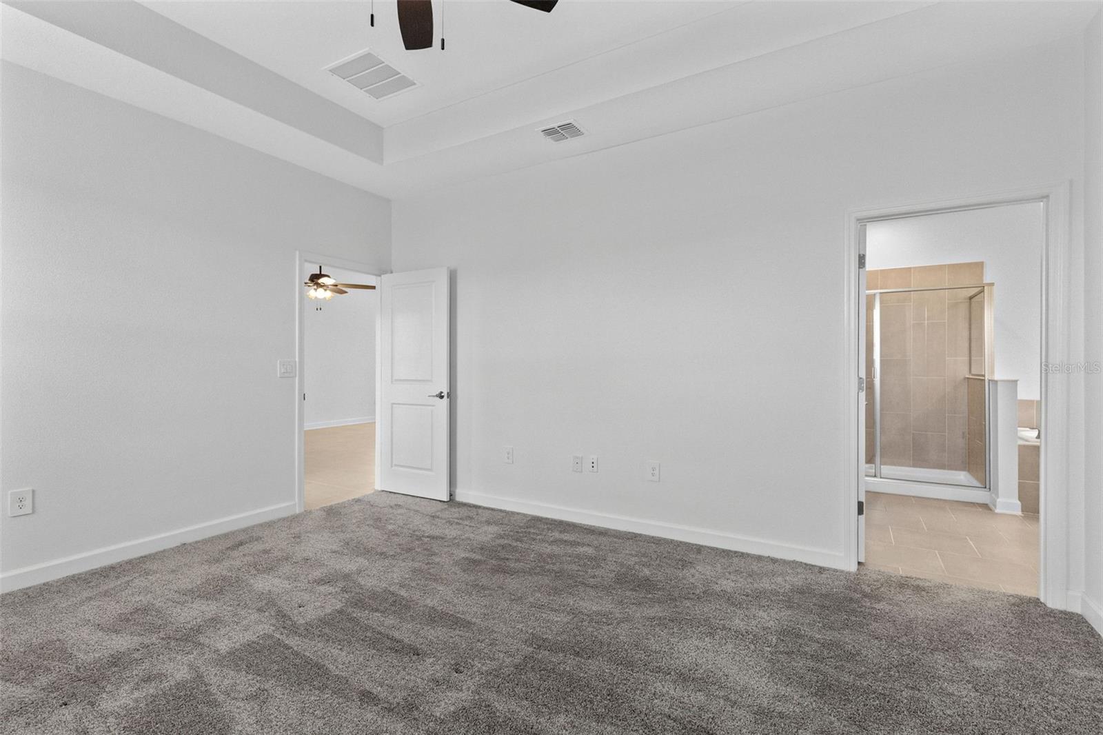 Tucked away at the rear of the home, the primary suite offers a generous walk in closet and a spacious private bathroom complete with quartz countertops, dual sinks, a soaking tub and separate shower. Direct access from the primary suite into the laundry room adds another layer of everyday convenience.