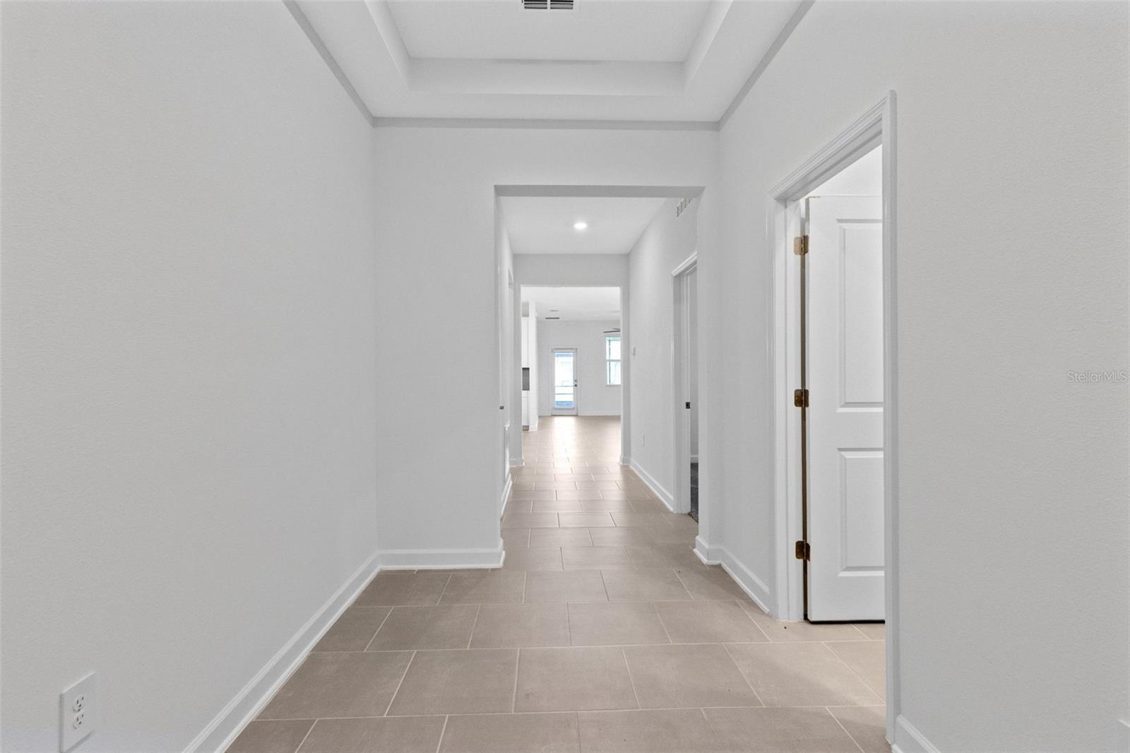 Step inside to a light and welcoming interior featuring high ceilings, a fresh neutral palette and ceramic tile throughout the main living areas.