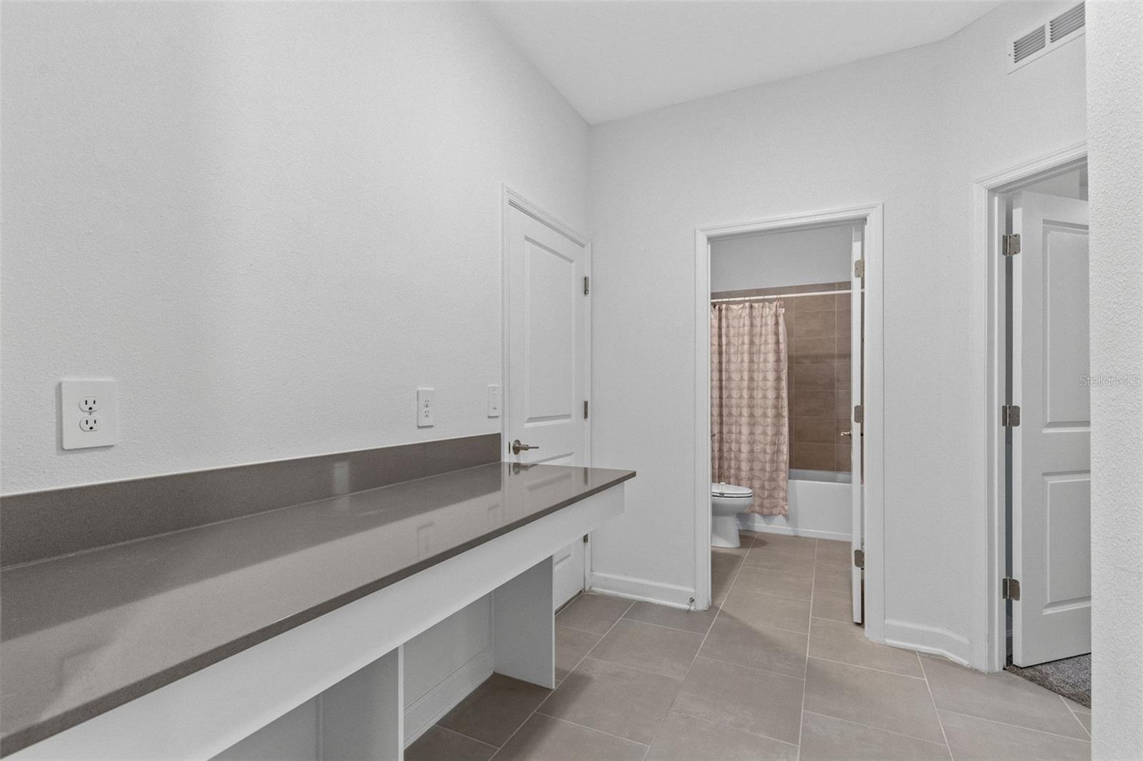 A built in desk and drop zone near the garage provide a dedicated place for homework, organization or working from home.