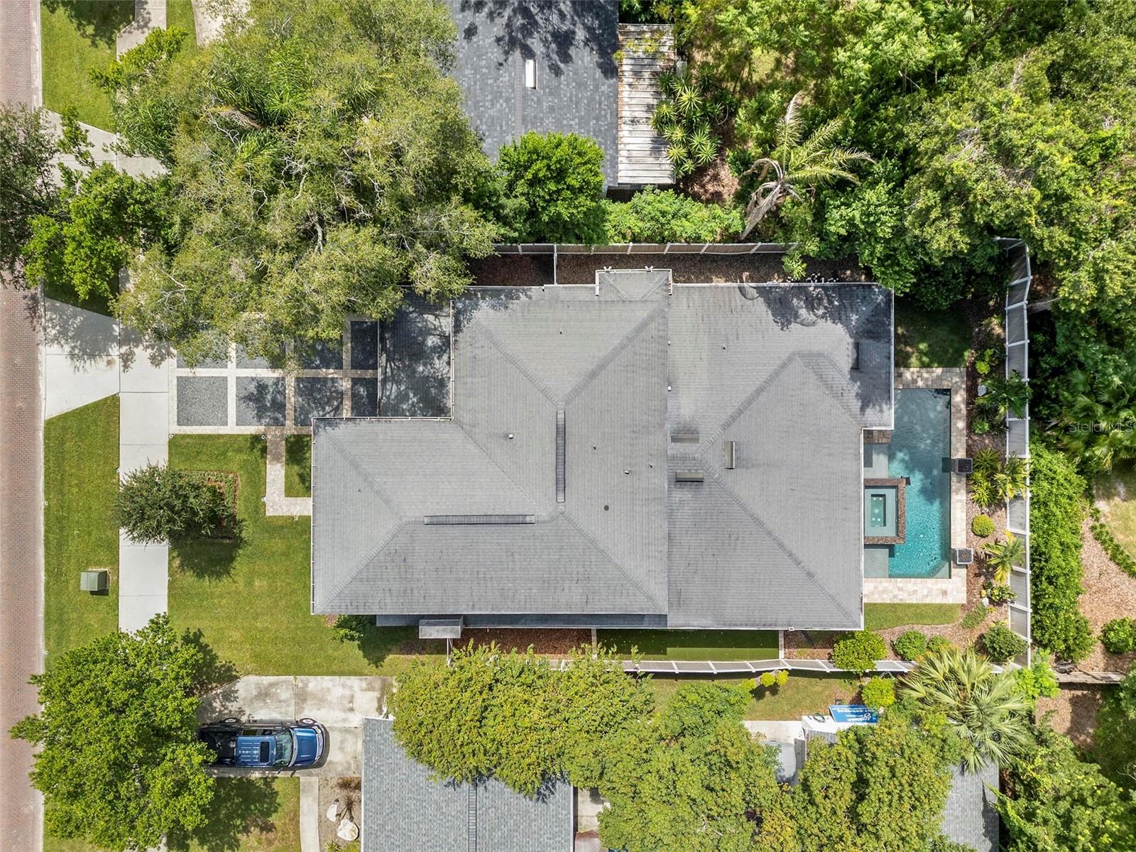 The home is surrounded by lush, mature trees.