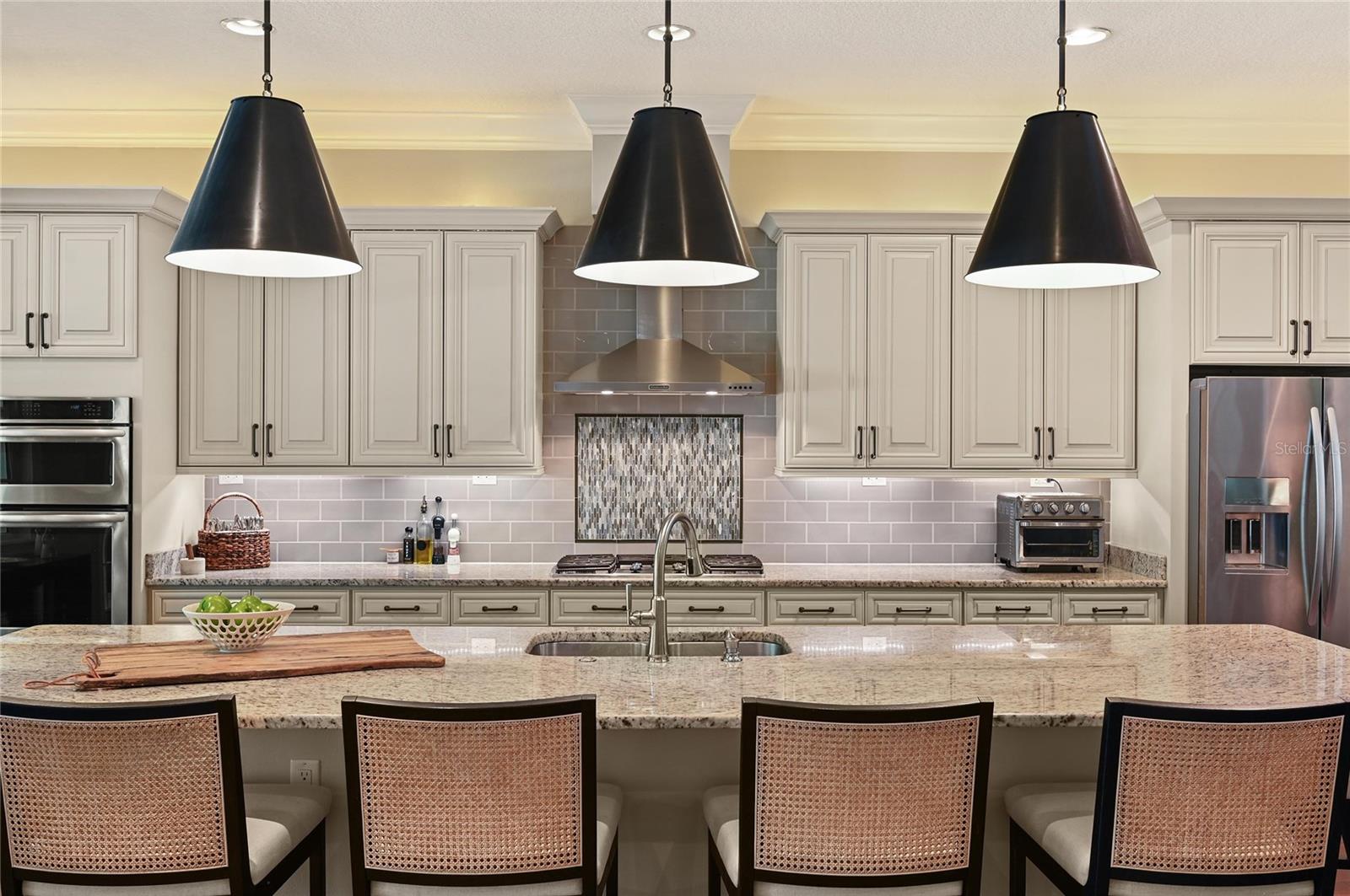 Pendant lights give a sense of warmth and highlight the beauty of the stone counter top.