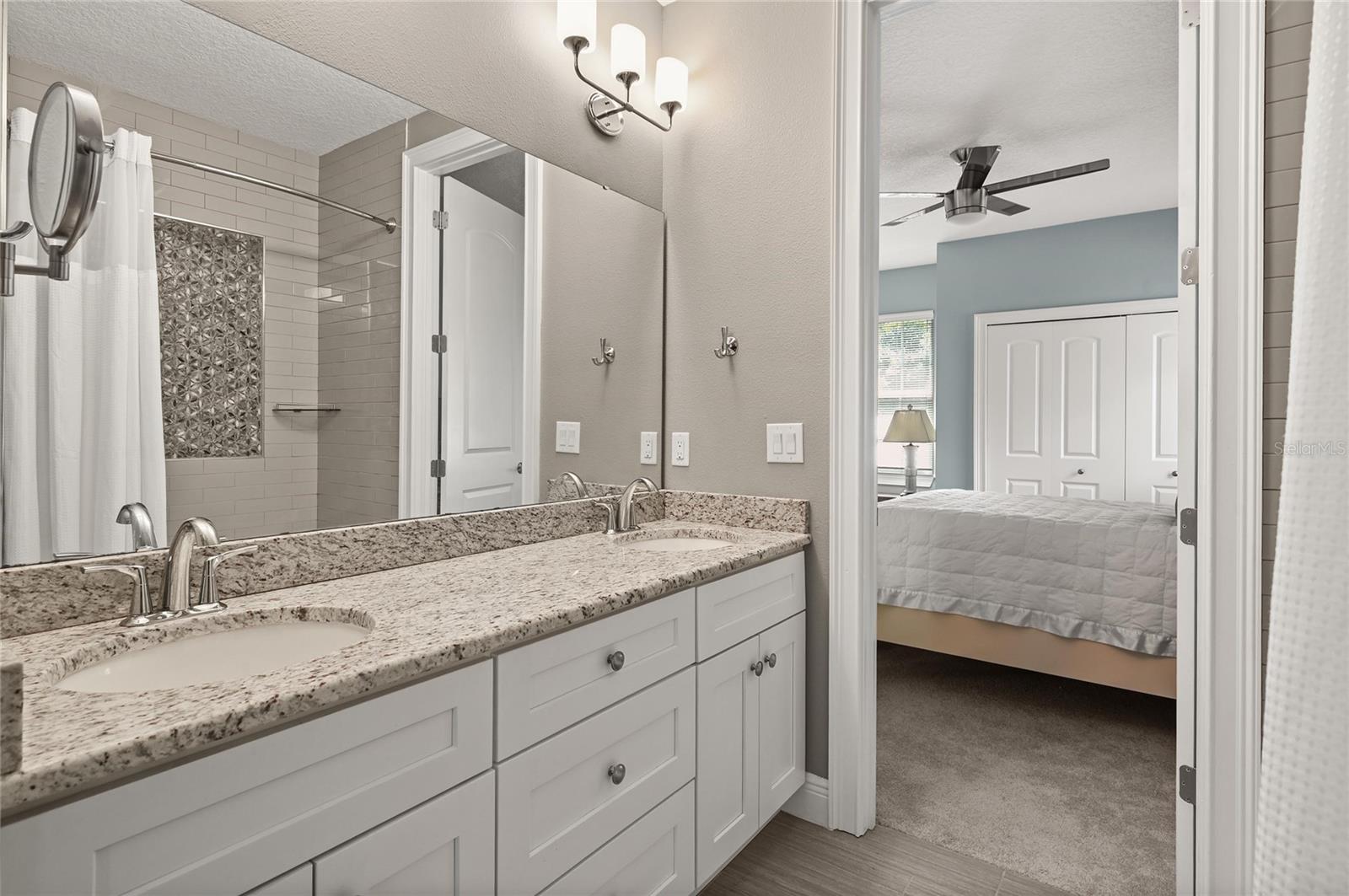 The bathroom features double sinks and a linen storage closet.