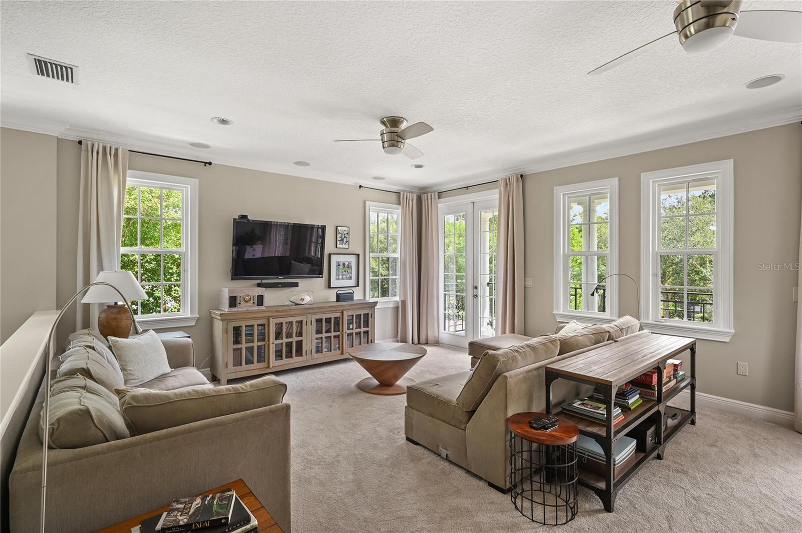 Double french doors let the light in and show off the surrounding tree canopy.