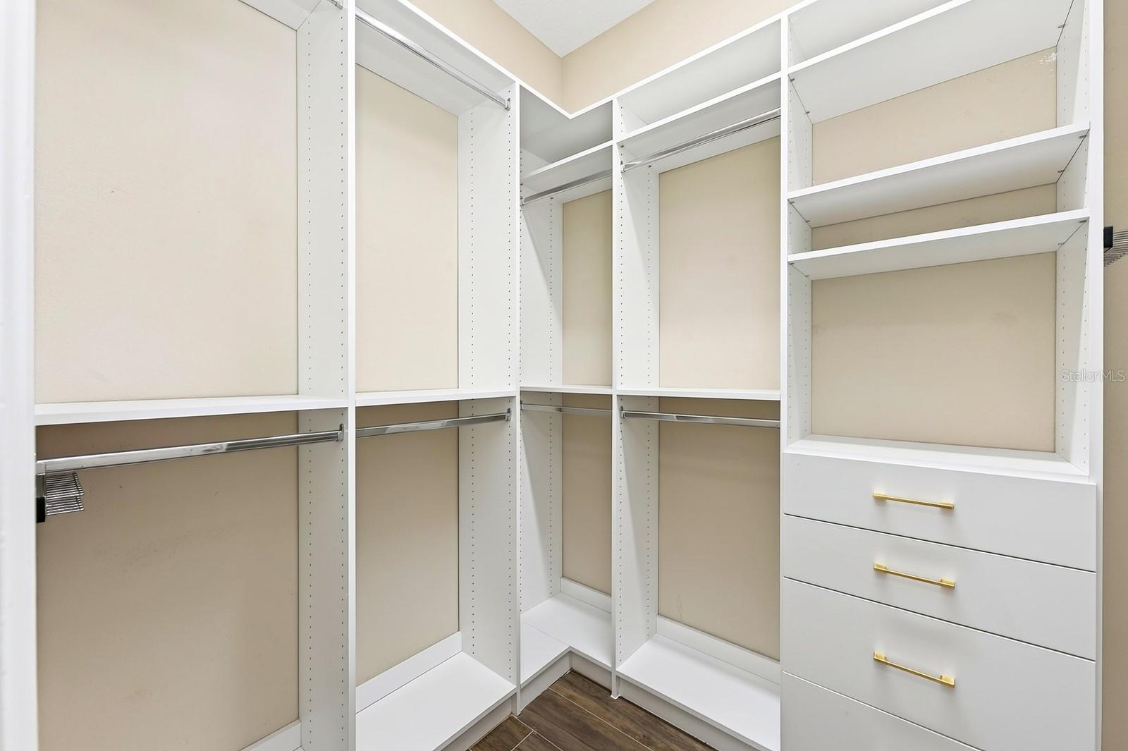 Primary suite walk-in closet with custom storage.