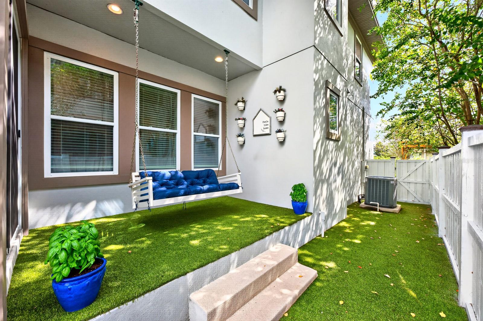 Low maintenance patio, privacy fenced sideyard finished with turf.