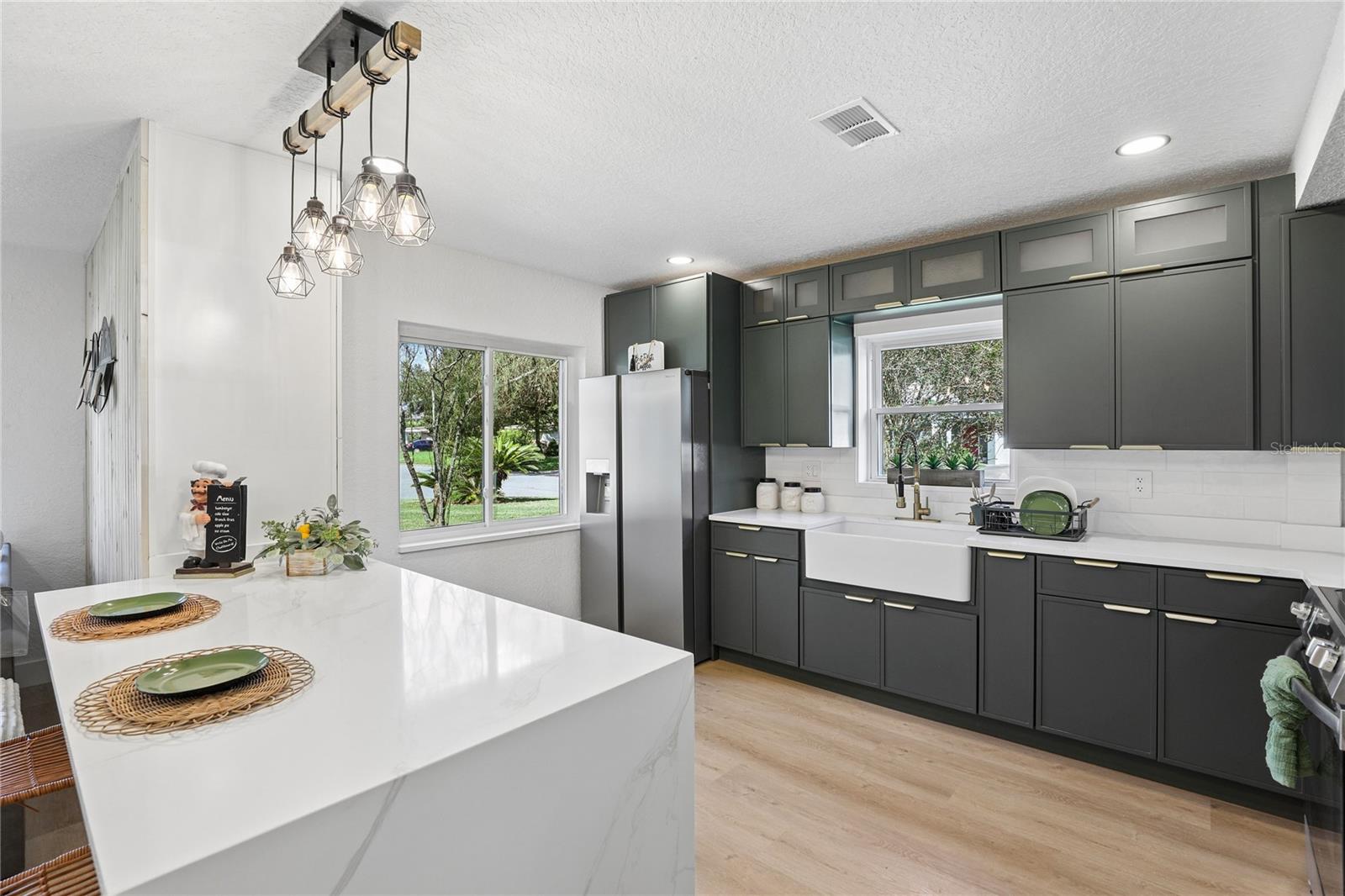 Waterfall-edge island with seating, storage and statement pendant lighting