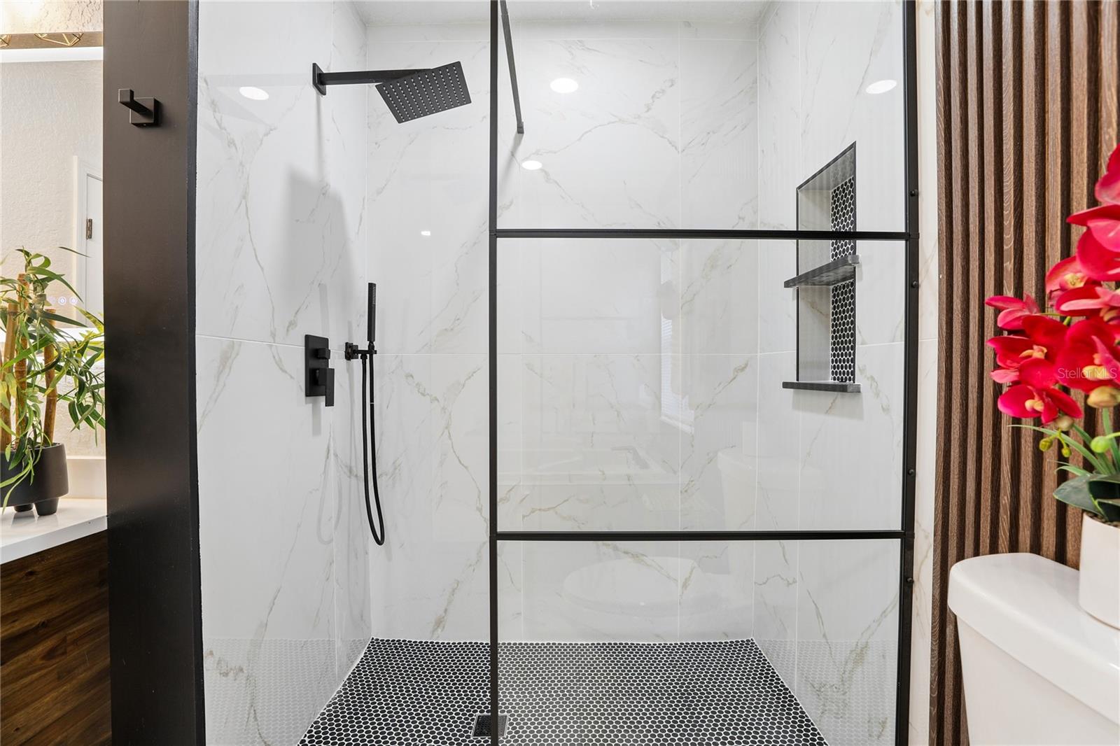 Separate glass-enclosed walk-in shower with rainfall showerhead