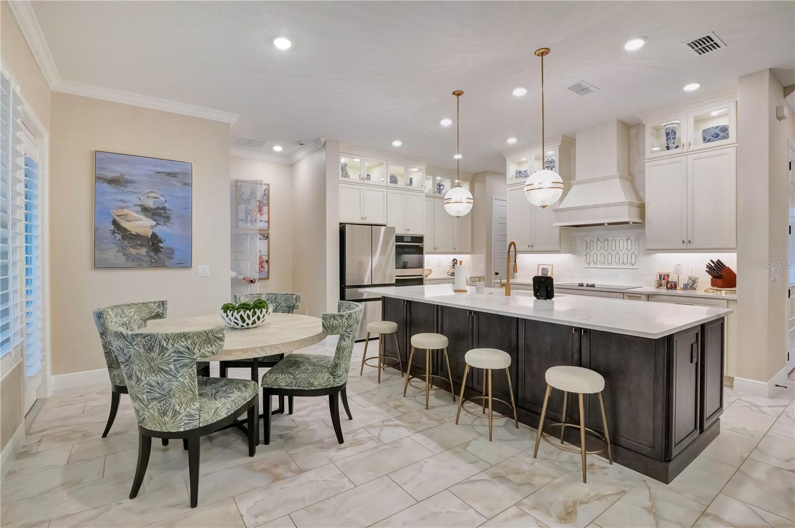 Spacious kitchen and breakfast area featuring upgraded tile flooring, crown molding and recessed lighting.
