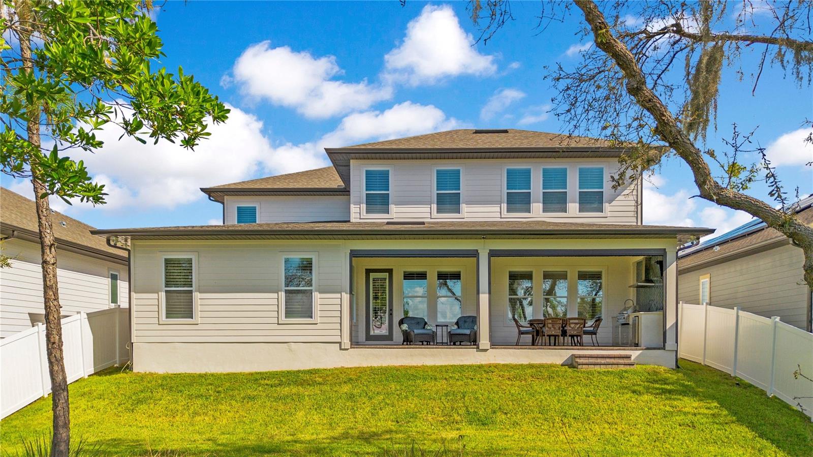 Spacious covered lanai with ceiling fans and roll-up screens extends the homes outdoor living space.