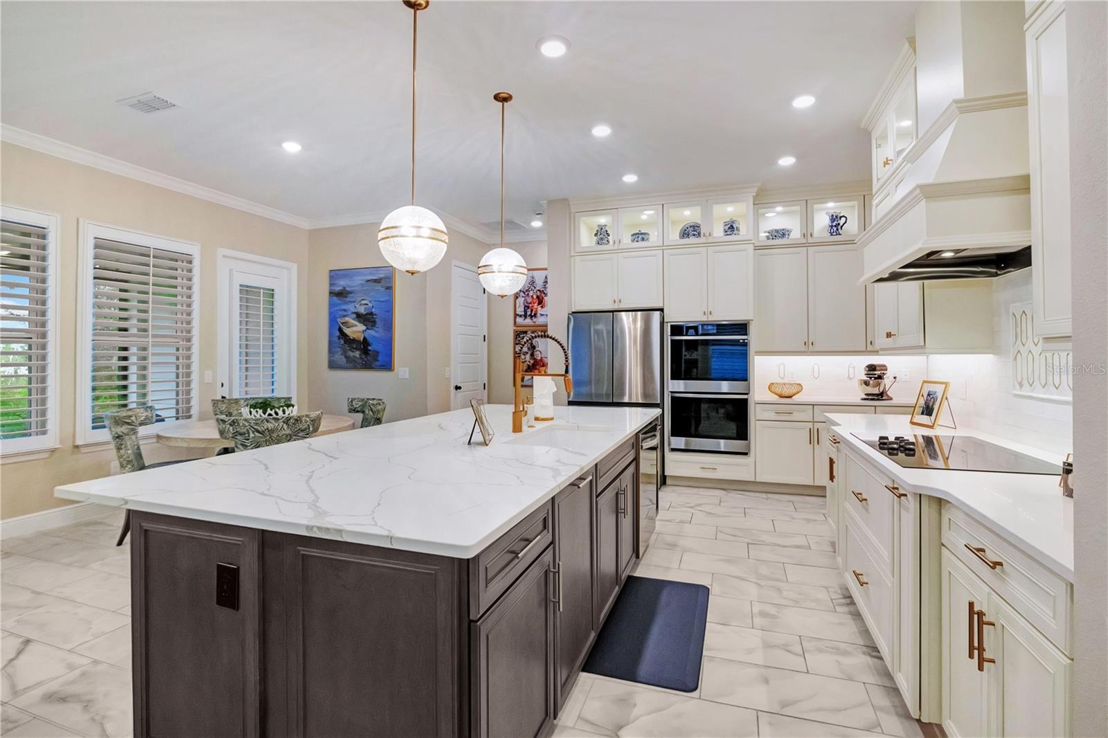 Beautifully appointed kitchen featuring a decorative backsplash, statement range hood and abundant cabinet storage.