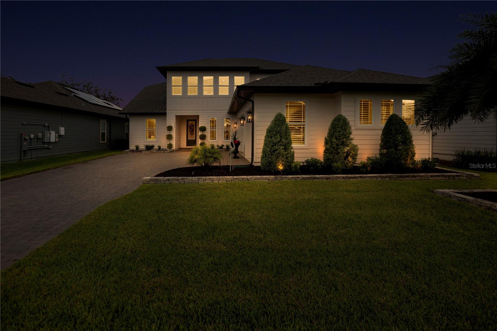 Twilight front view showcases the homes welcoming entrance and landscape lighting.