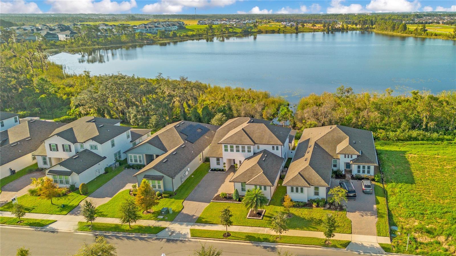 Aerial view showcasing the homes scenic setting with the lake behind it.