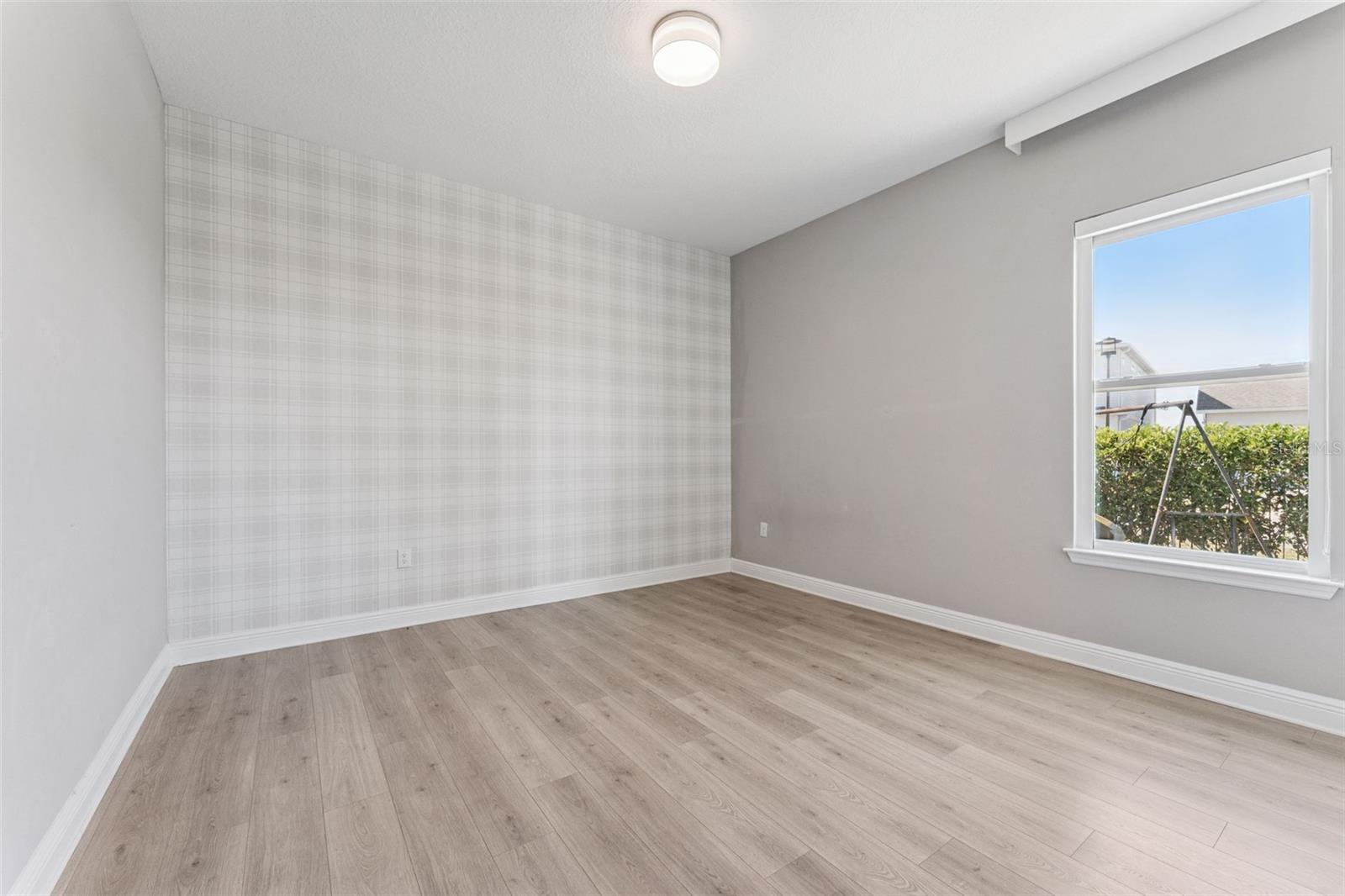 Spacious third bedroom with a bright, open feel.
