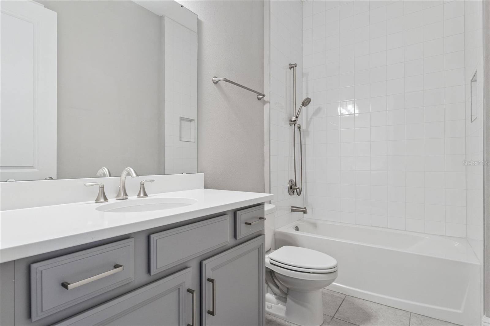 Additional full bathroom with modern finishes and tub/shower combination.