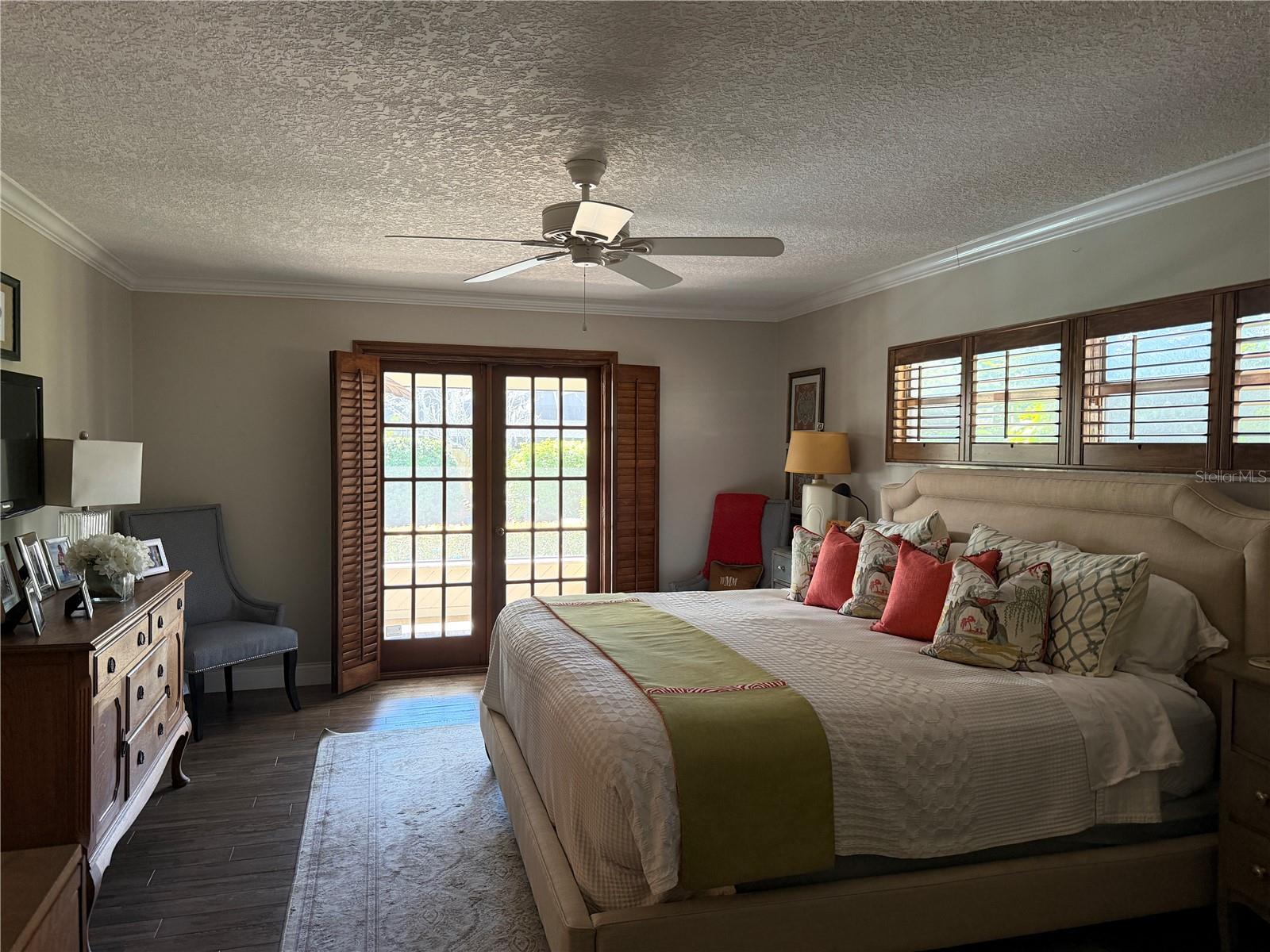 Primary bedroom with french doors to screened porch and pool