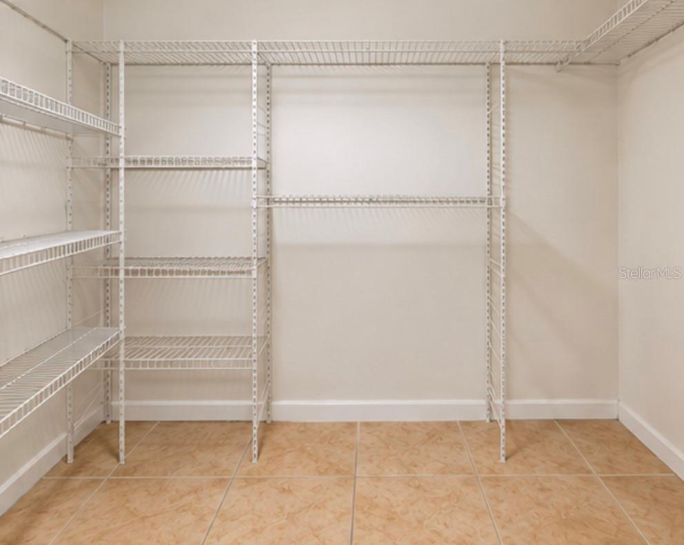 Spacious walk-in closet with added shelving.