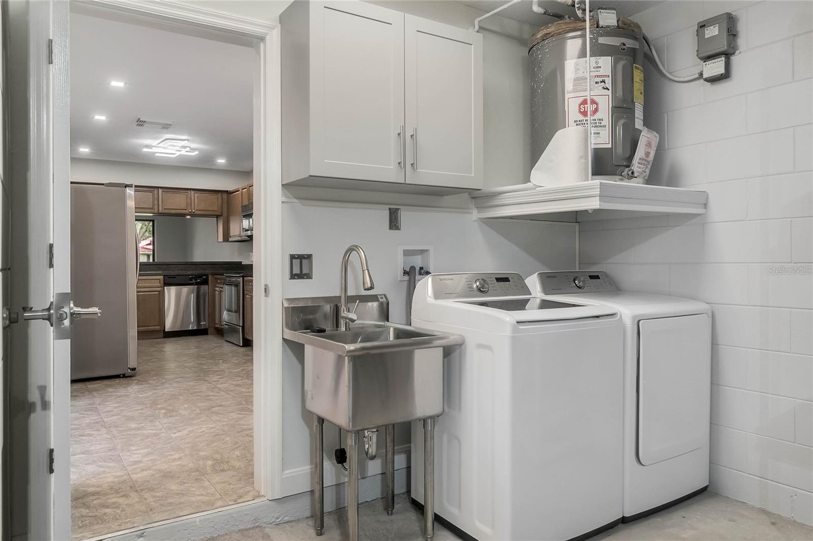 Garage laundry area with washer and dryer space and a utility sink for added convenience.