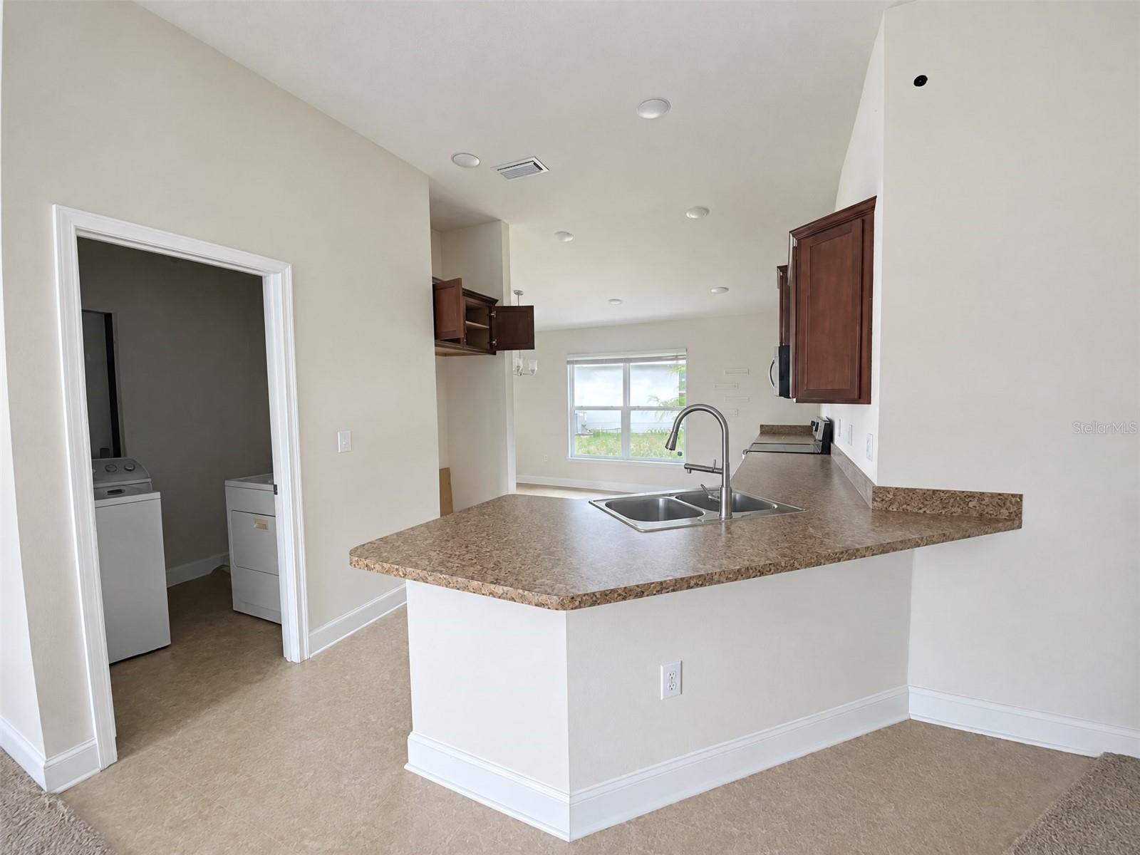 Kitchen, Peninsula with Counter Seating, with Eat in Dining Area. View of Laundry Room.