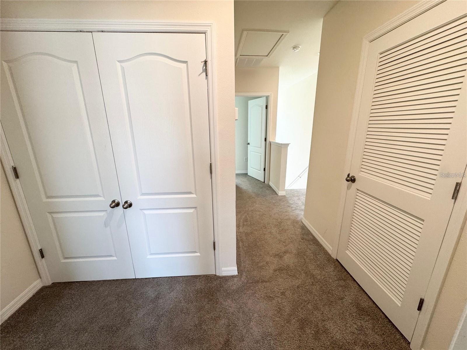 View of second story, enclosed laundry room and primary bedroom entrance.