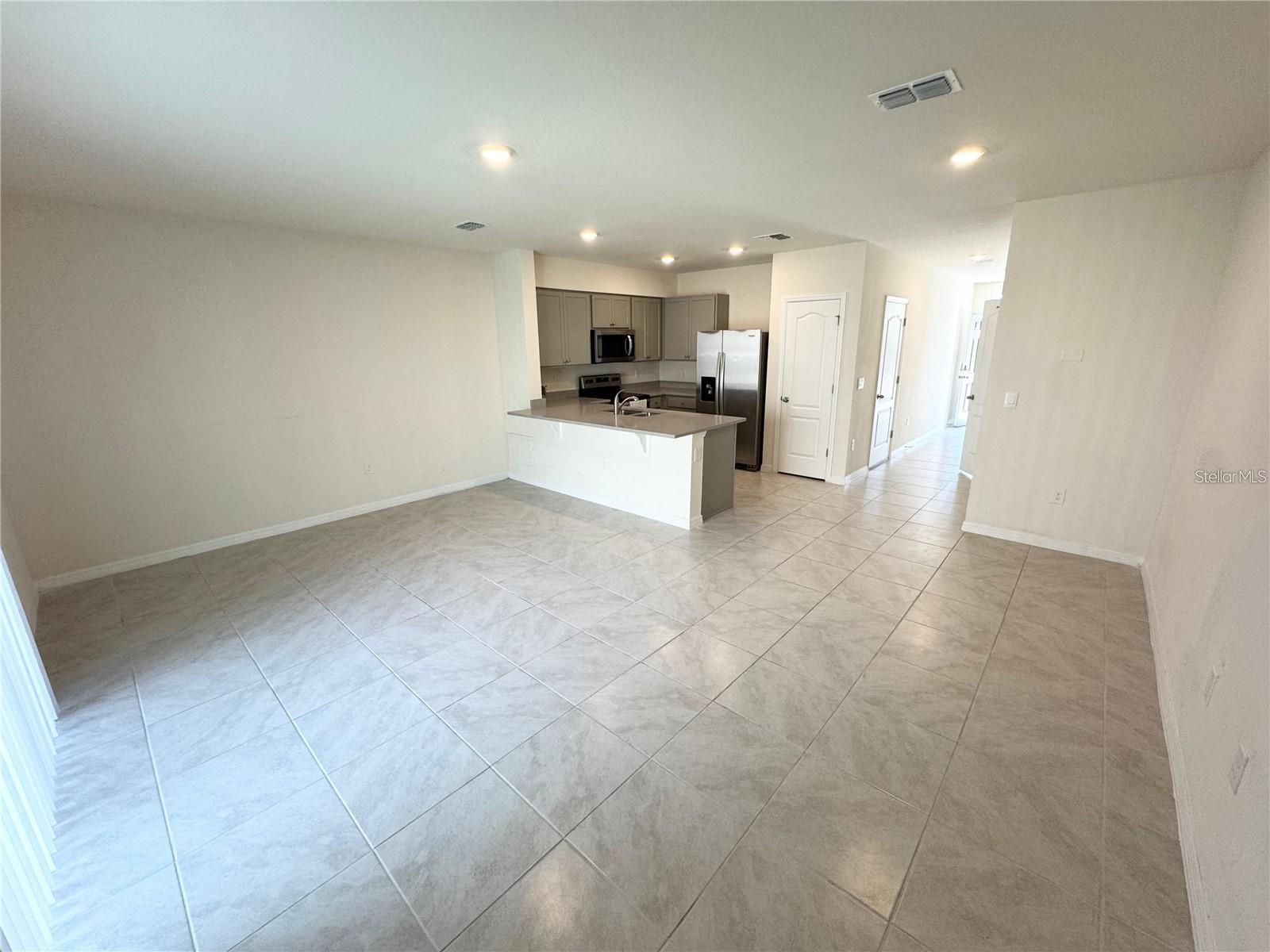 View of living room, dining room combo toward breeze way and entrance.