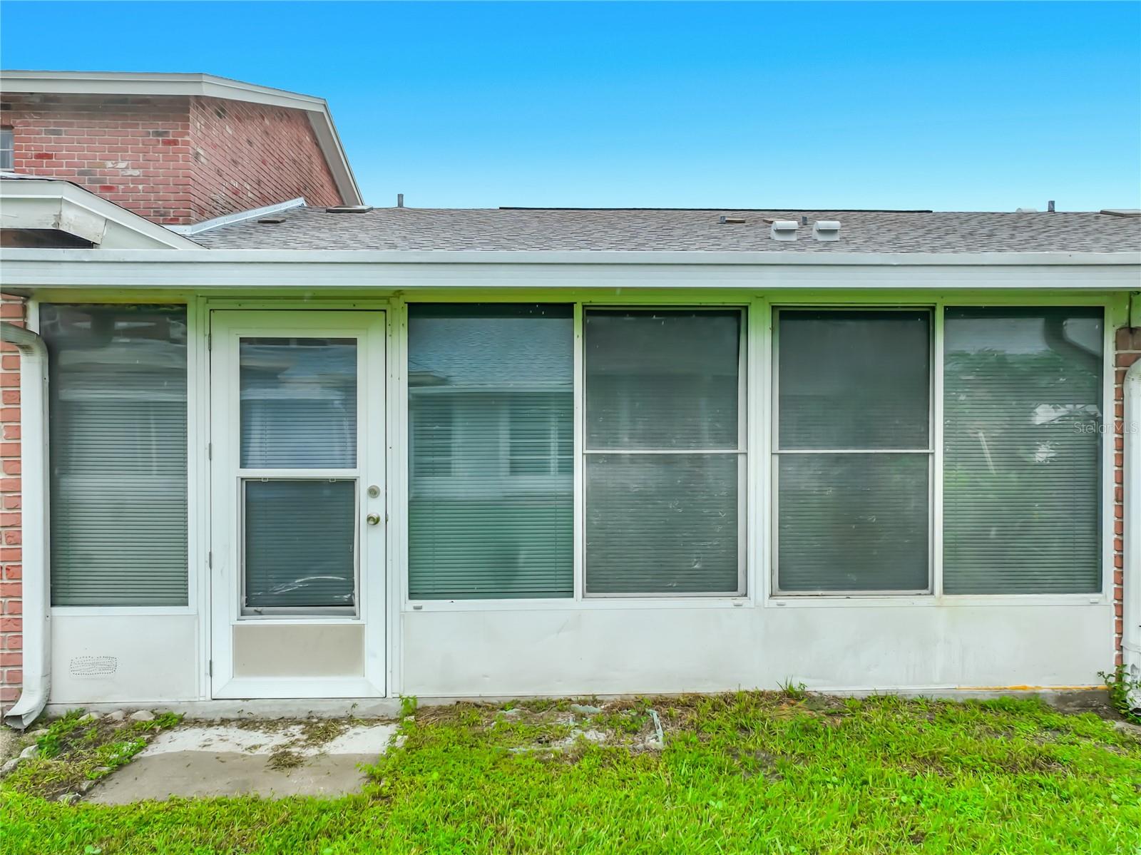 Exterior view showcasing the home's large enclosed Florida room.
