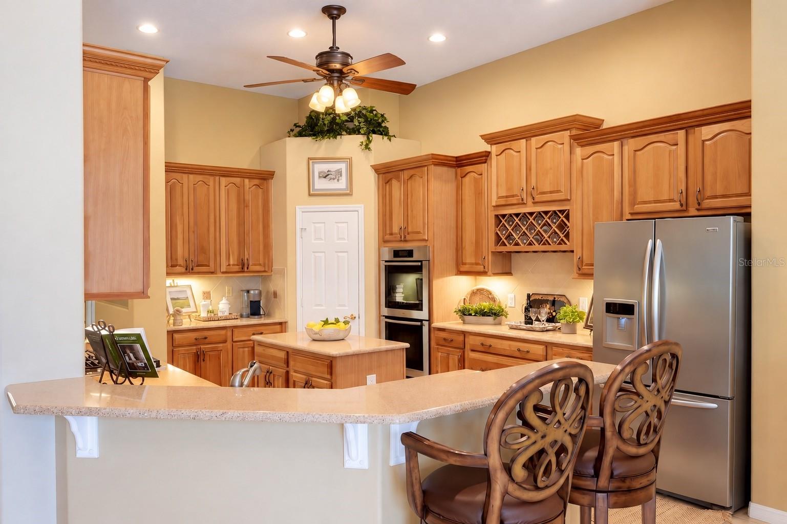 CENTER ISLAND, EXPANSIVE BREAKFAST BAR WITH SEATING, BUILT-IN DOUBLE OVENS, STAINLESS STEEL APPLIANCES, CUSTOM WINE RACK, AND CONVENIENT PANTRY! CENTER ISLAND, EXPANSIVE BREAKFAST BAR WITH SEATING, BUILT-IN DOUBLE OVENS, STAINLESS STEEL APPLIANCES, CUSTOM WINE RACK, AND CONVENIENT PANTRY!