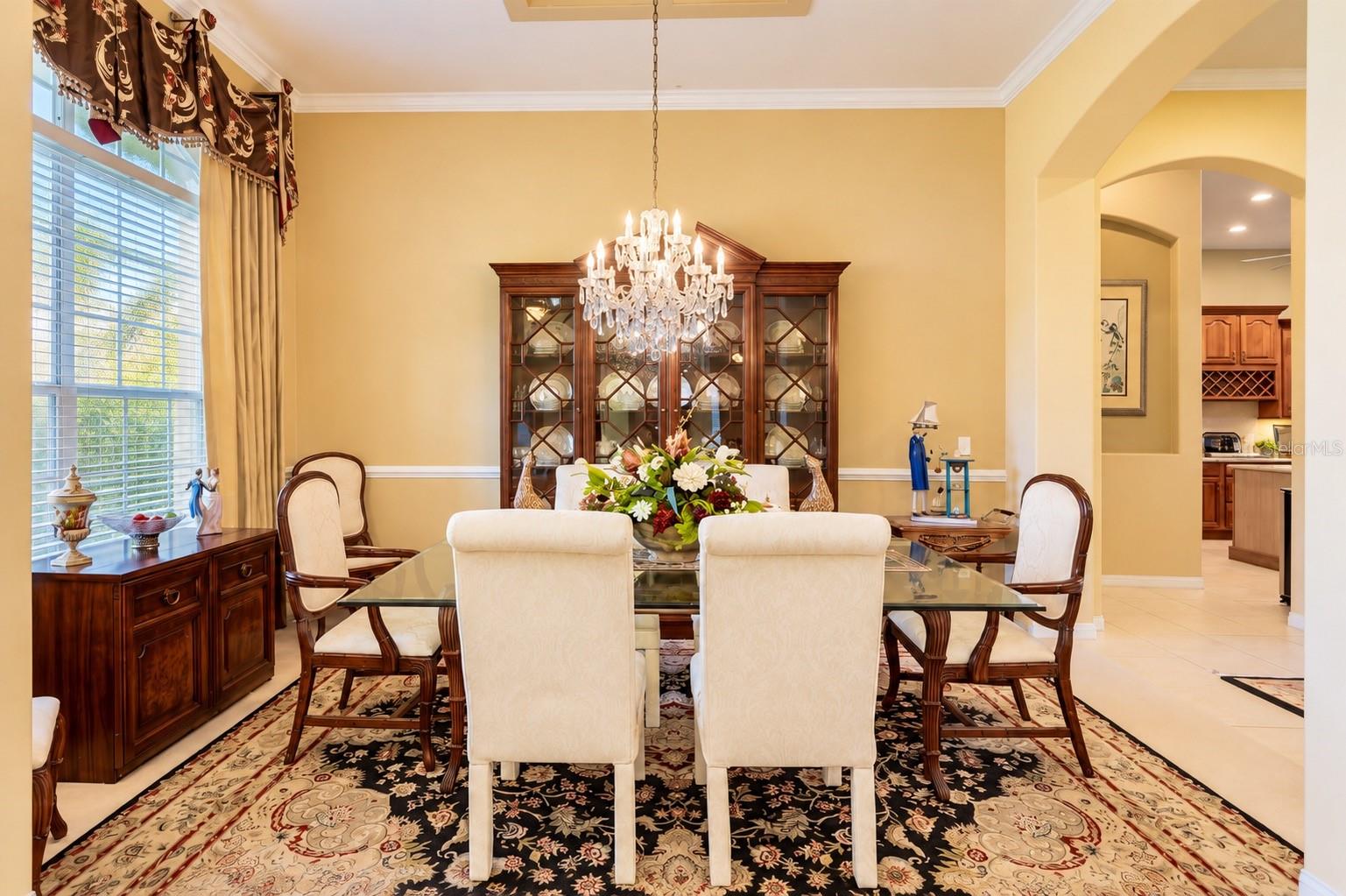 ELEGANT FORMAL DINING ROOM FEATURING SOARING CEILINGS, BEAUTIFUL CROWN MOLDING, and DECORATIVE CHAIR RAIL! A large window fills the room with natural light, while graceful architectural archways create an inviting flow to the kitchen, making this the perfect space for hosting holiday gatherings, special celebrations, and memorable dinners with family and friends! ELEGANT FORMAL DINING ROOM FEATURING SOARING CEILINGS, BEAUTIFUL CROWN MOLDING, and DECORATIVE CHAIR RAIL! A large window fills the room with natural light, while graceful architectural archways create an inviting flow to the kitchen, making this the perfect space for hosting holiday gatherings, special celebrations, and memorable dinners with family and friends!