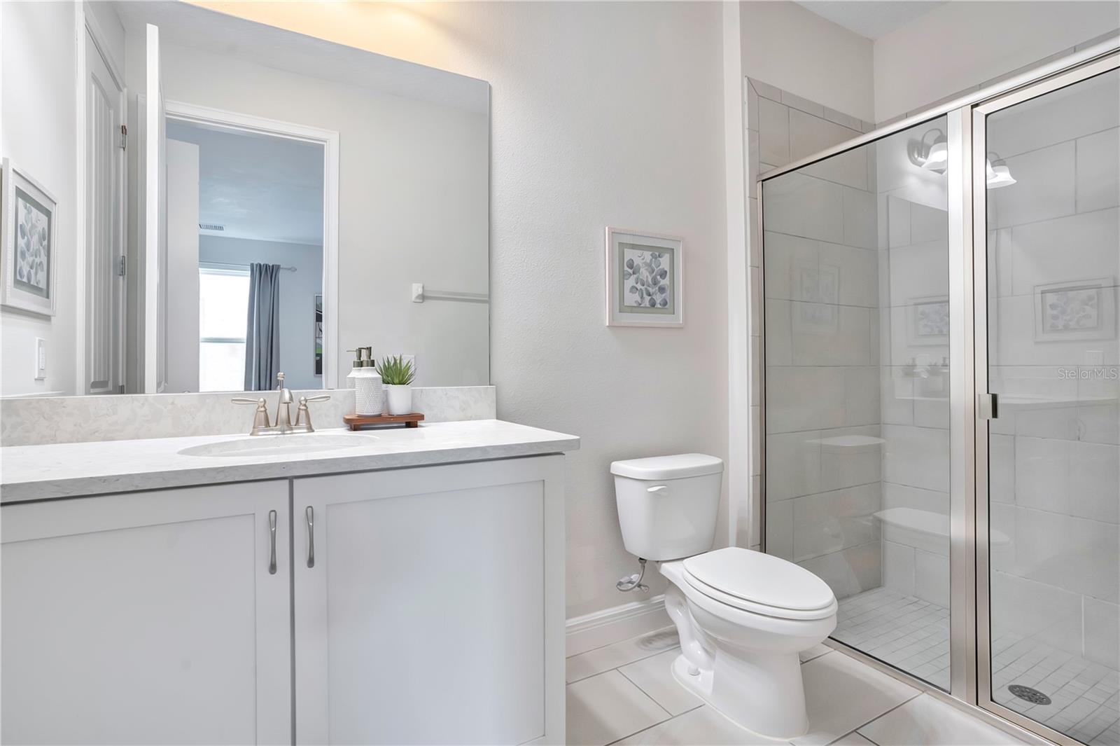 Private en-suite bath featuring a contemporary vanity and glass-enclosed shower