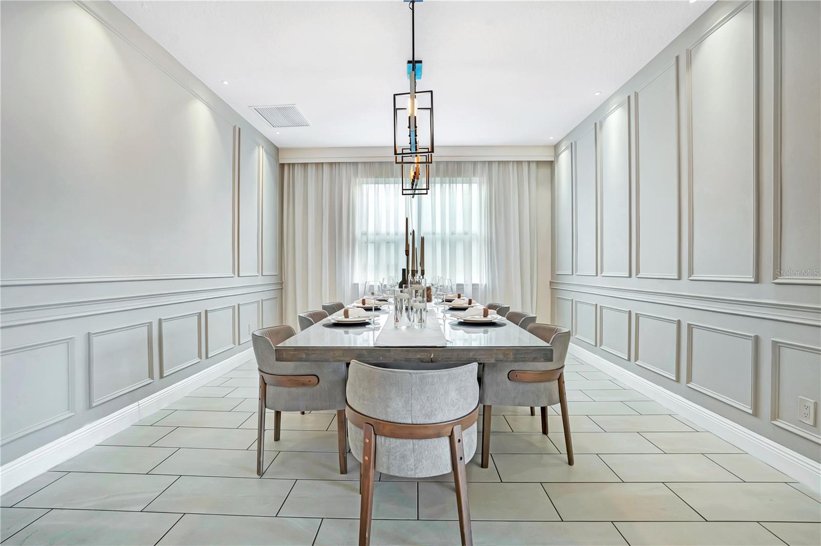 Refined formal dining with custom decorative millwork and seating for ten