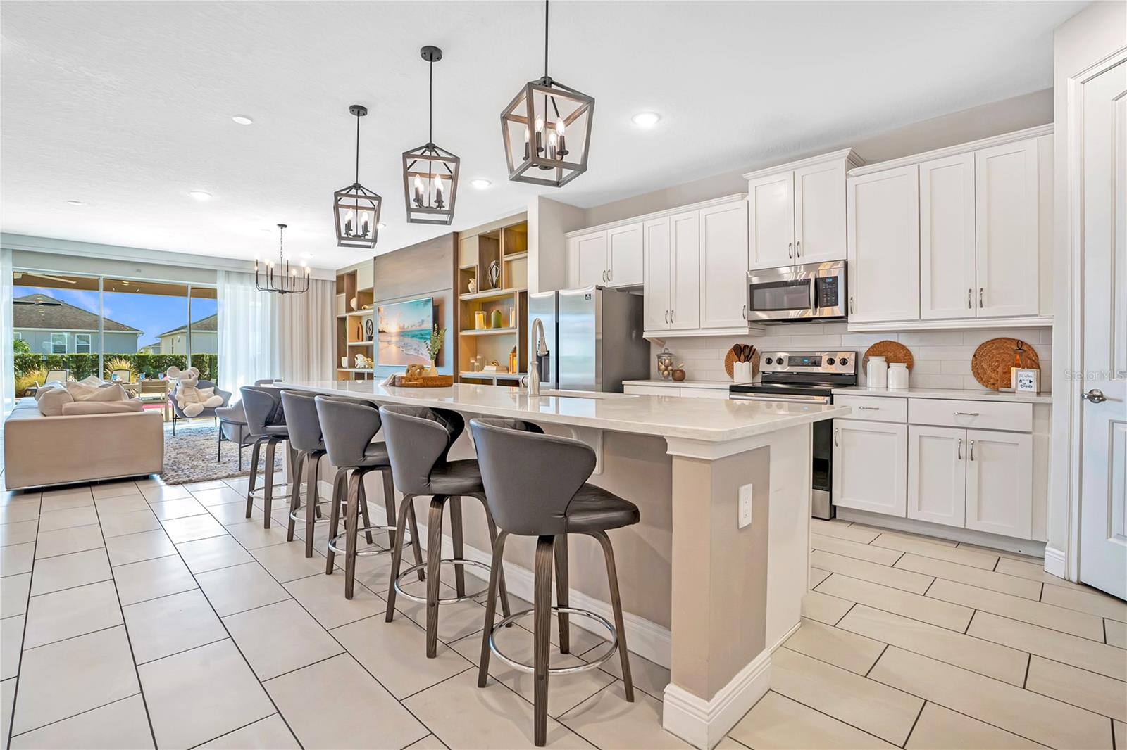 The expansive kitchen and adjoining living areas offer seamless flow, generous island seating, and an ideal layout for bringing everyone together